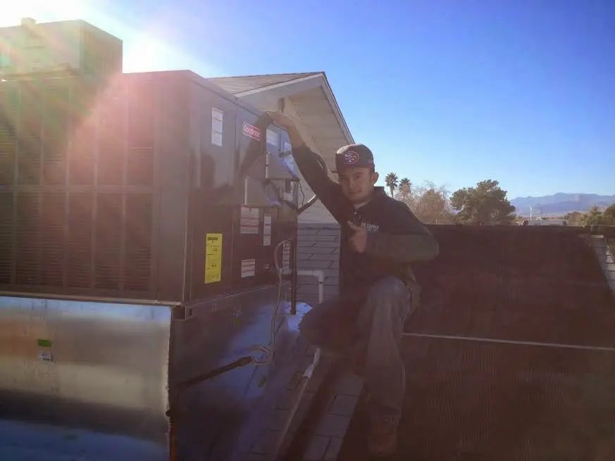 HVAC technician performing Air Duct Repair on a rooftop unit in Cottleville